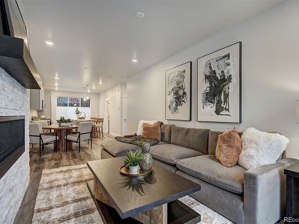 Open-concept living room with sectional and stone fireplace