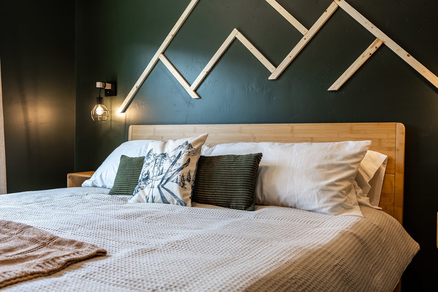 Primary bedroom with a king bed and green accent wall